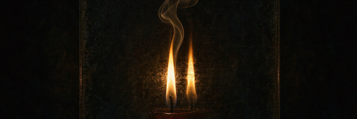 Candle flame doubled by dark smoked glass with curling smoke against absolute black