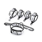 Clear PVC bondage set collar handcuffs and ankle cuffs laid out - Dominitoy 252401233T