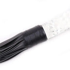 Close-up of Dominitoy leather flogger tail base and textured glass handle