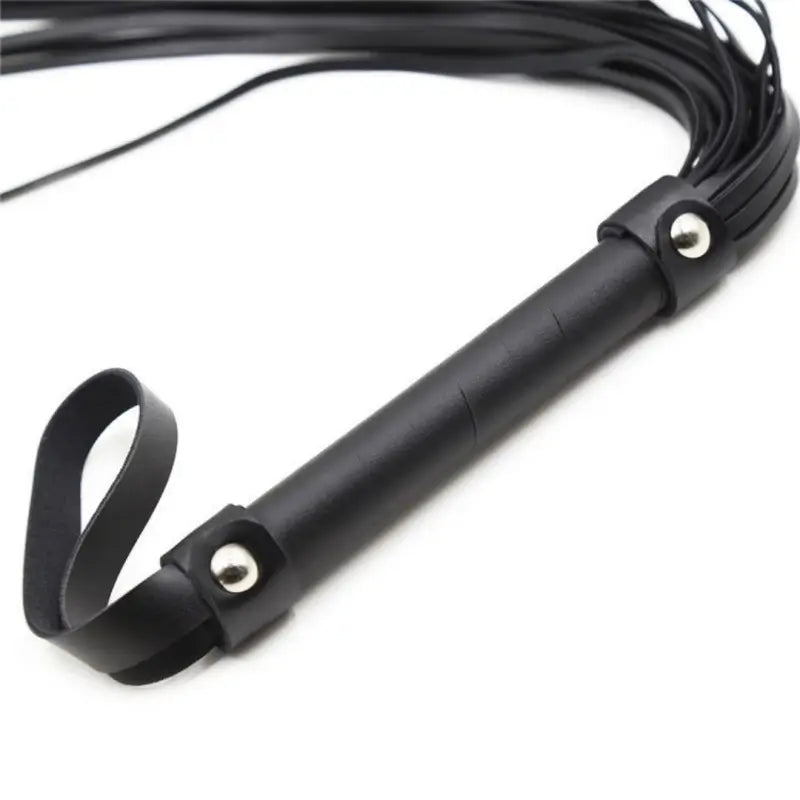 Close-up of Dominitoy black flogger studded handle and leather wrist loop
