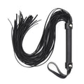 Dominitoy black PU leather flogger with studded handle laid on white background