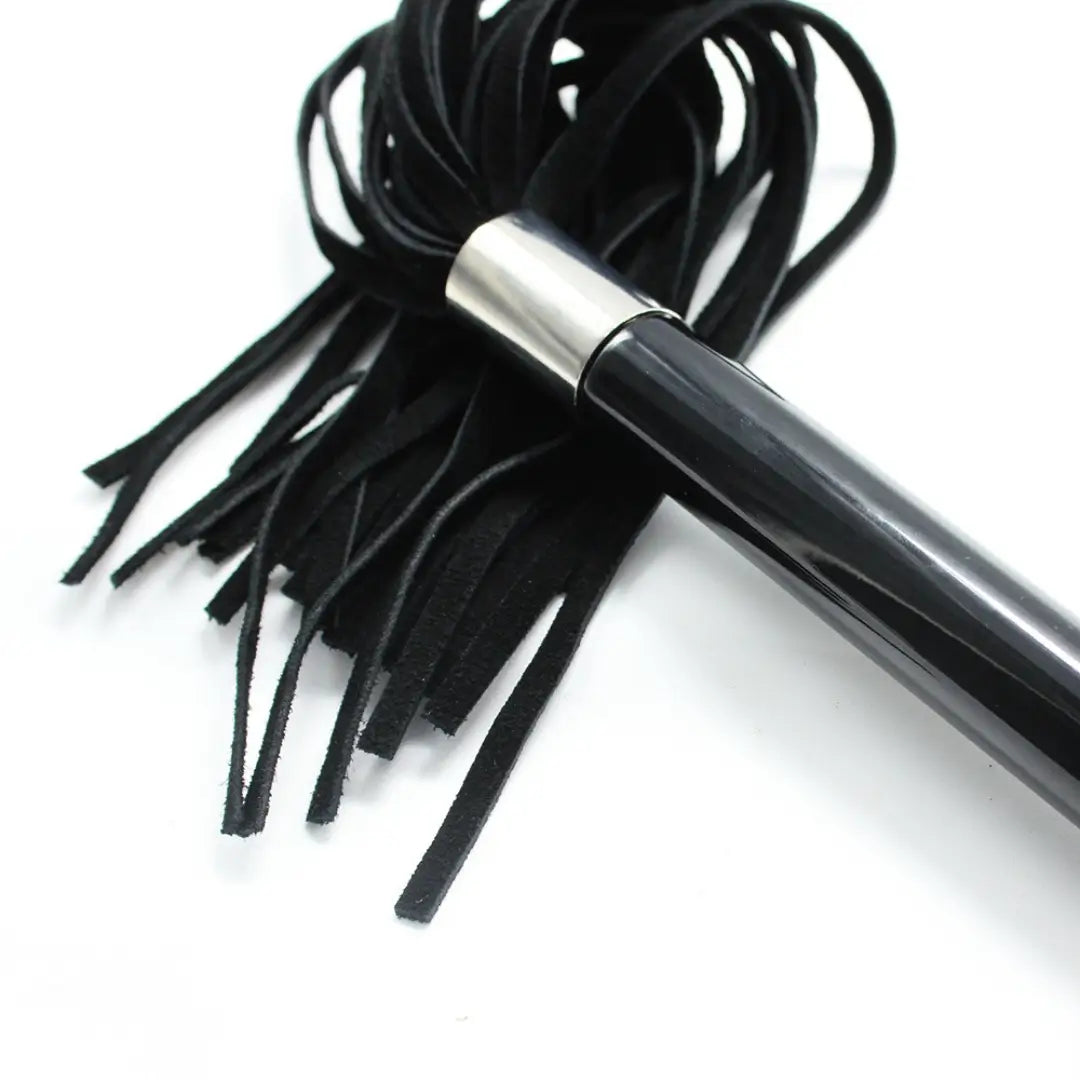Close-up of Dominitoy suede flogger metal ball handle and suede tails
